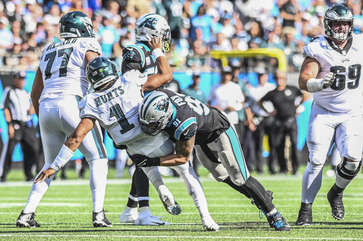 Oct 10, 2021; Charlotte, North Carolina, USA; Carolina Panthers defensive end Morgan Fox (91) sacks Philadelphia Eagles quarterback Jalen Hurts (1) during the second half at Bank of America Stadium. Mandatory Credit: Griffin Zetterberg-USA TODAY Sports